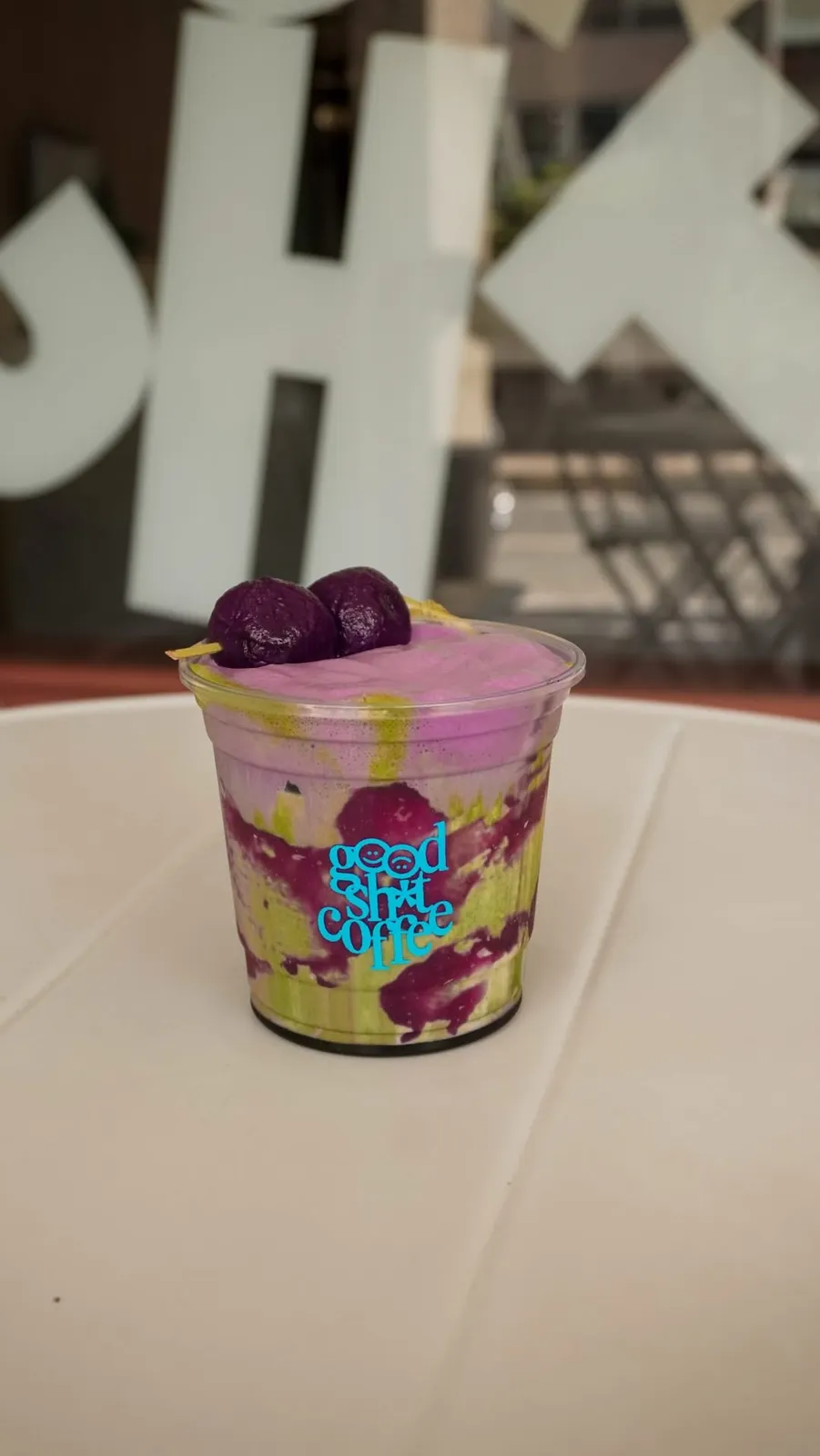 Purple and green Ube Matcha Dango drink in a Good Sh*t Coffee cup