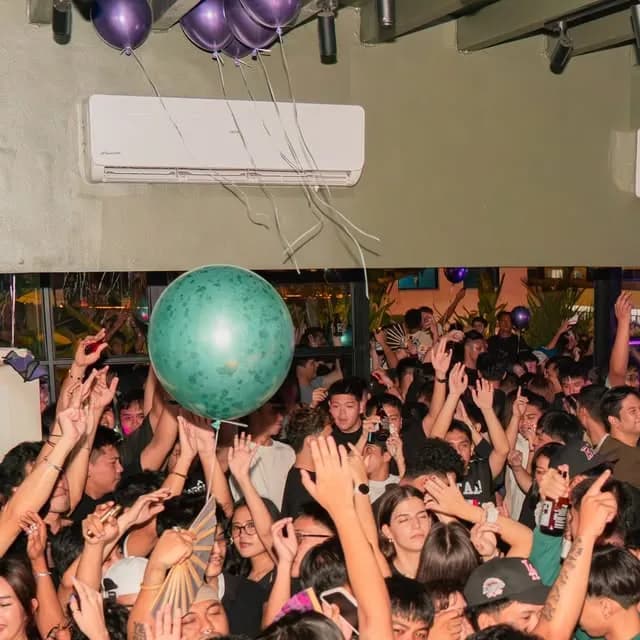Anniversary crowd dancing under balloons at Sanctuary