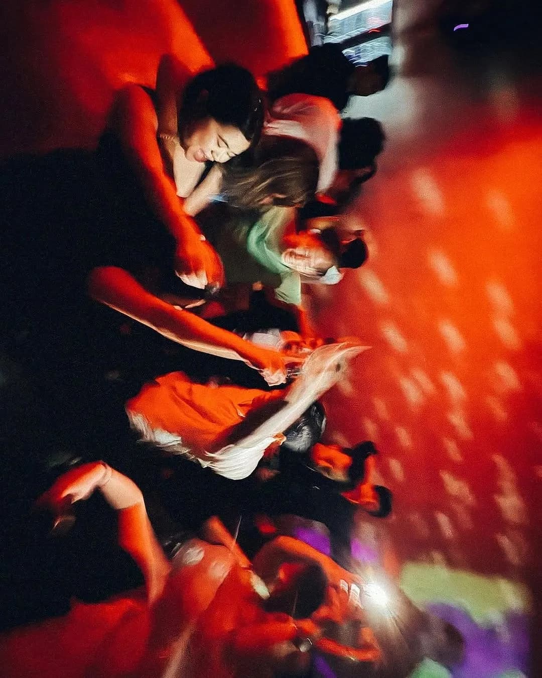 Guests dancing under red light on Tango's compact dance floor.