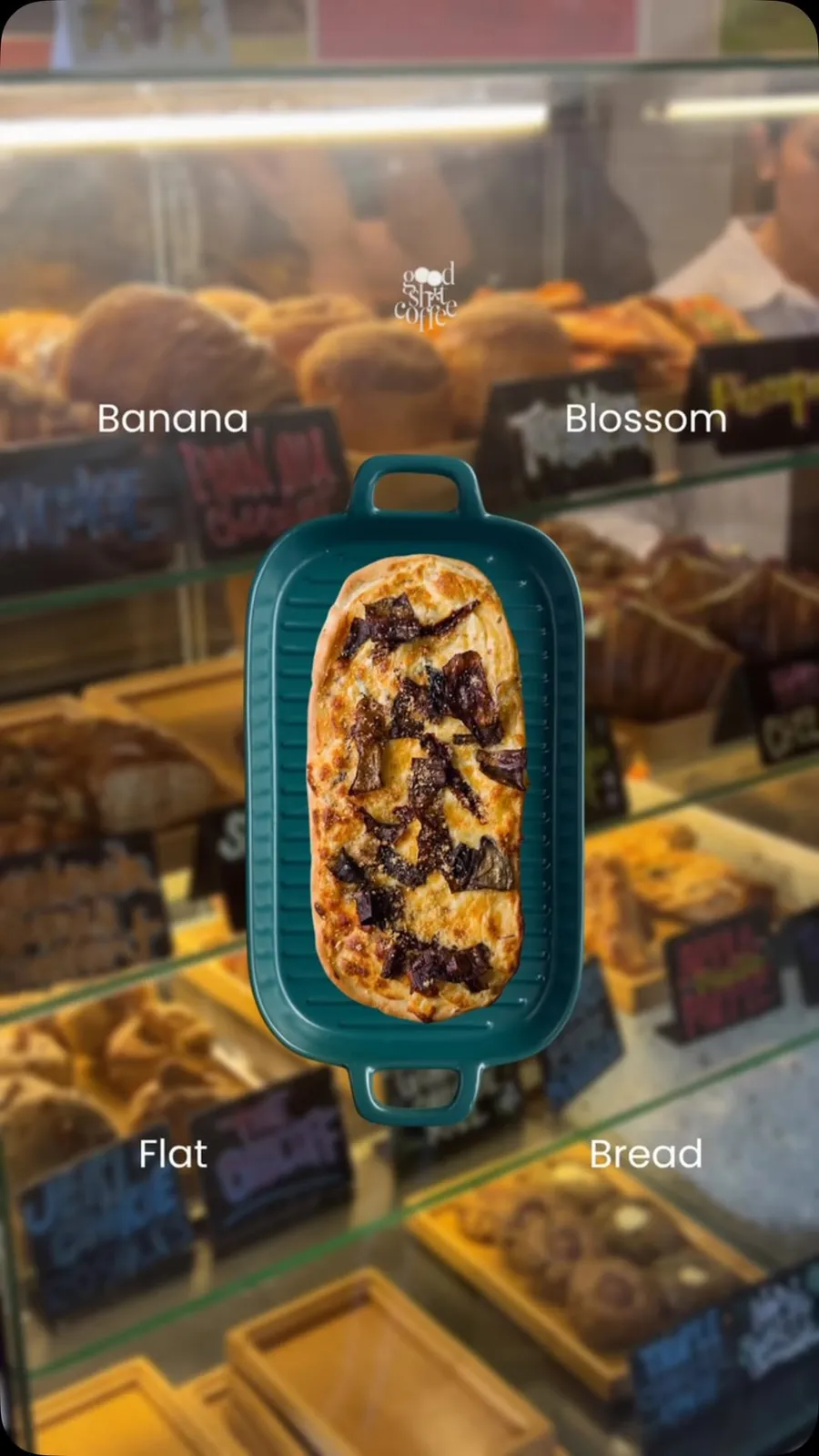 Two oval flatbreads topped with vegetables and herbs on metal trays