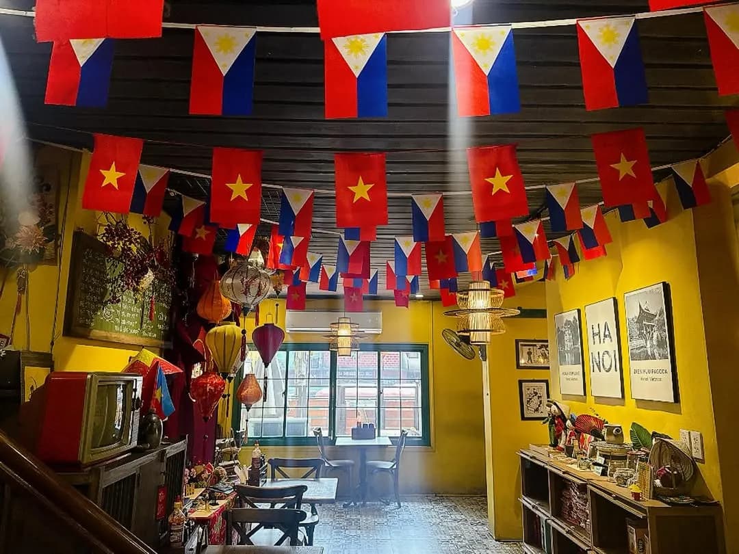 Yellow dining room hung with Philippine and Vietnamese flags