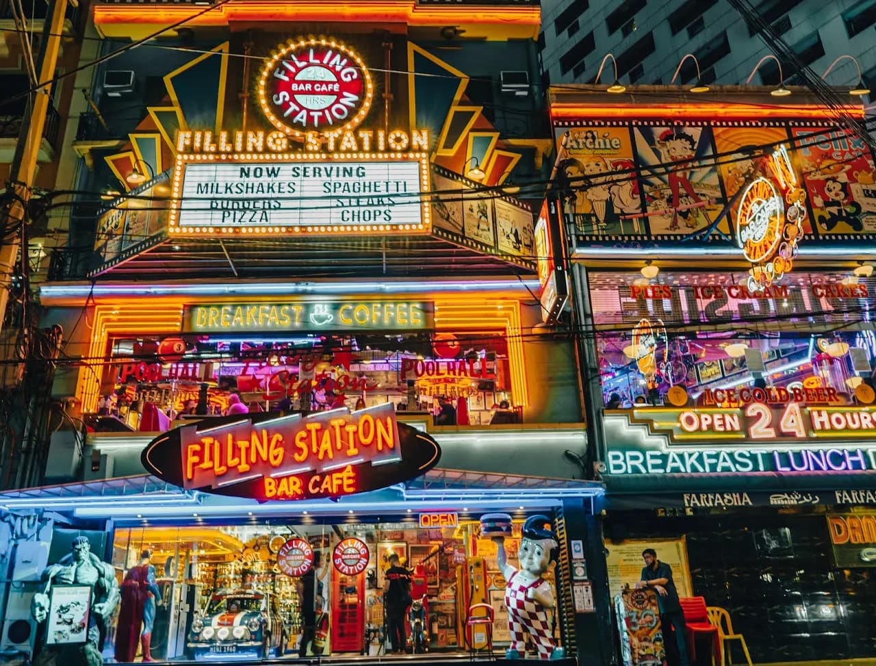 Neon-lit Filling Station facade on P. Burgos Street at night.