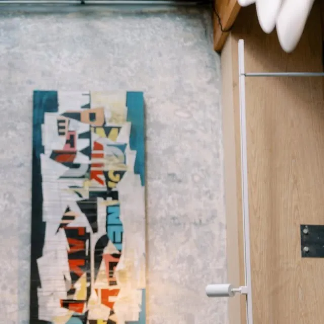 Dining room wall with a large abstract artwork and warm ceiling lights