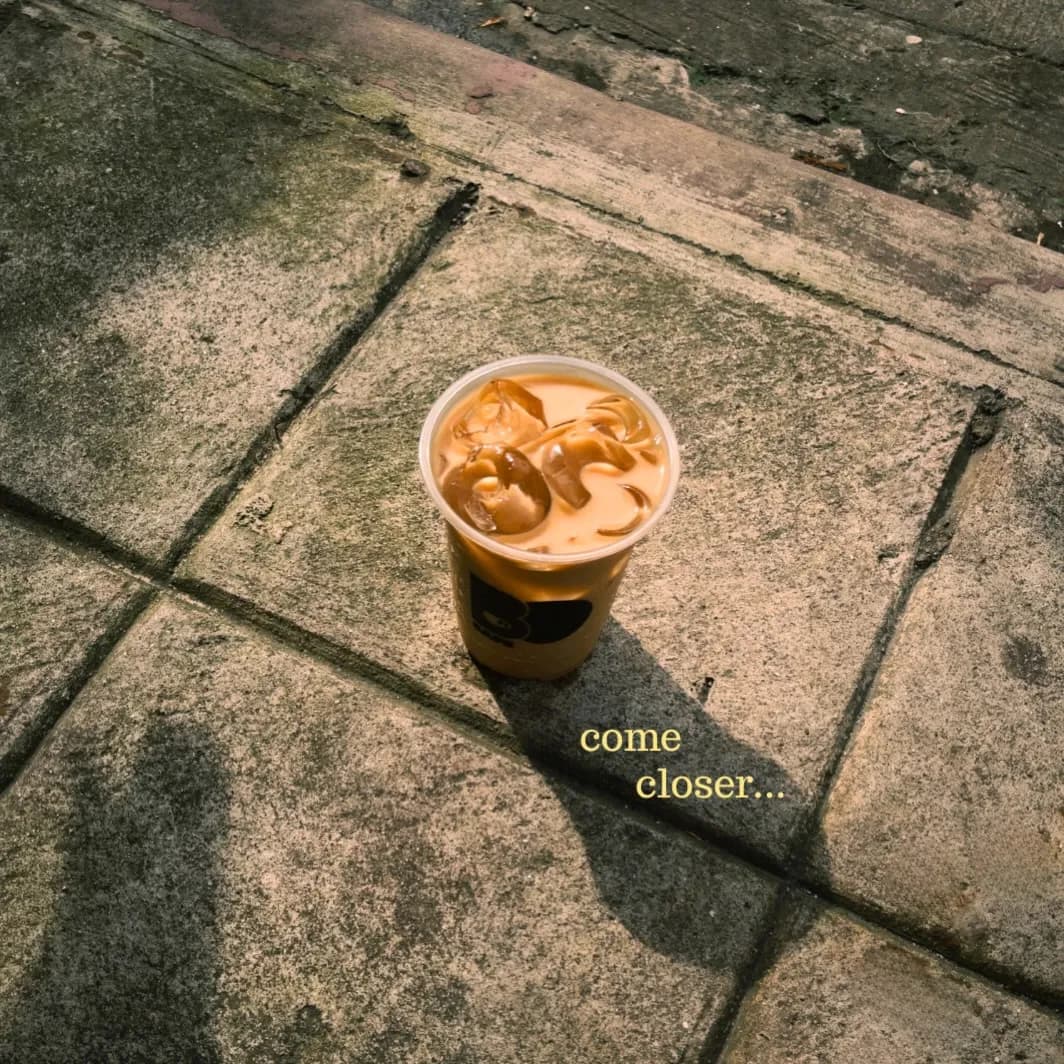 Iced coffee in a branded cup on concrete steps