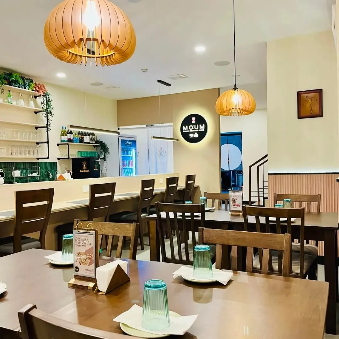 Bright MOUM dining room with wooden tables and chairs