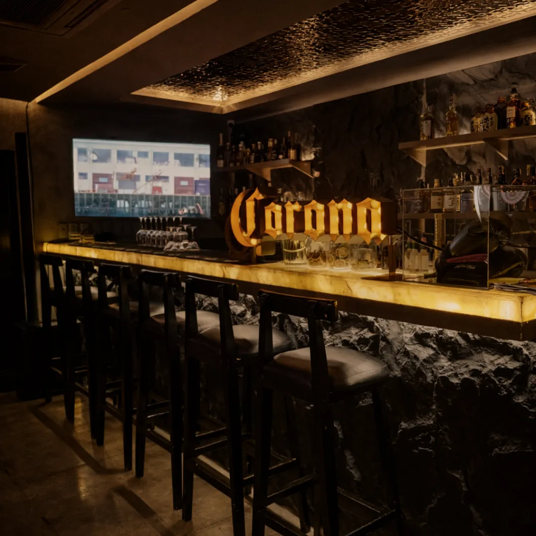 Illuminated bar counter with stools in the lounge