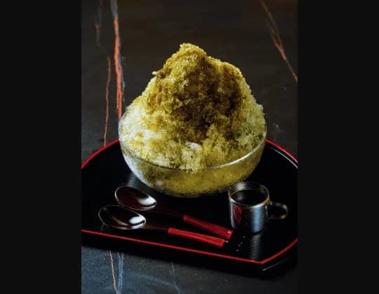 Green tea shaved ice served on a black tray