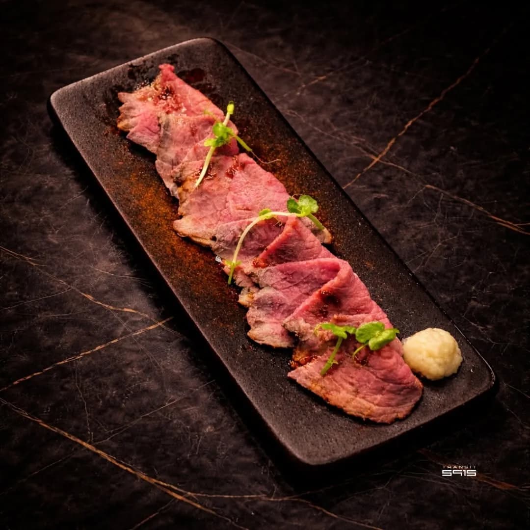 Slices of Japanese-style roast beef on a black plate