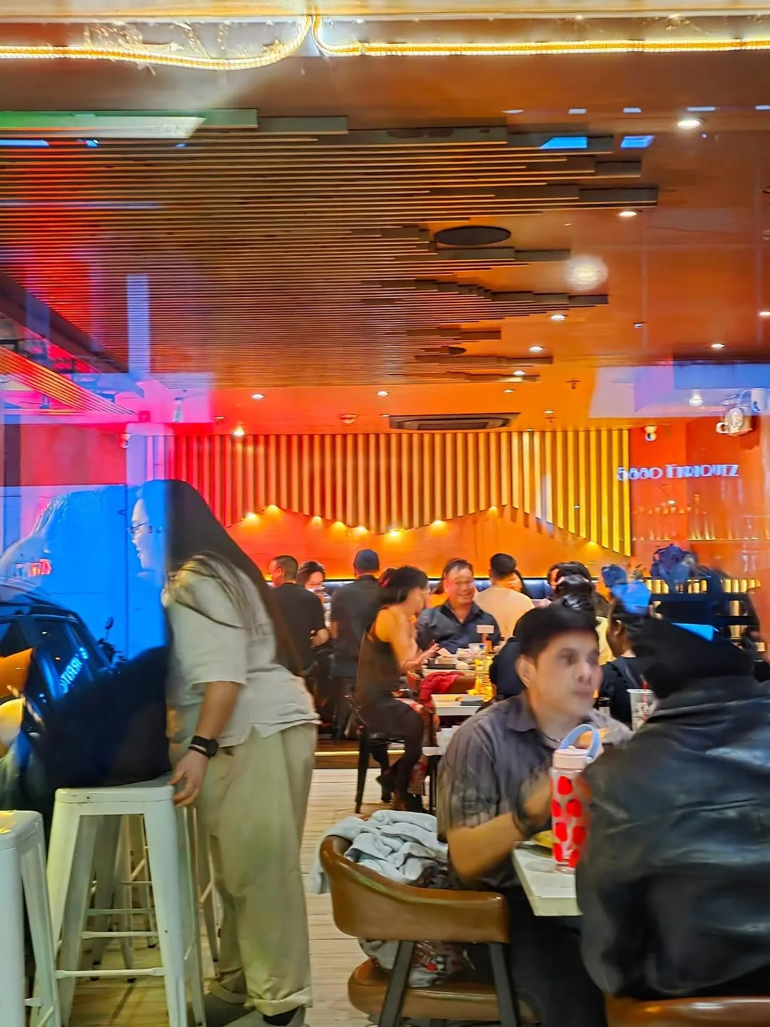 Bright orange dining room filled with evening guests