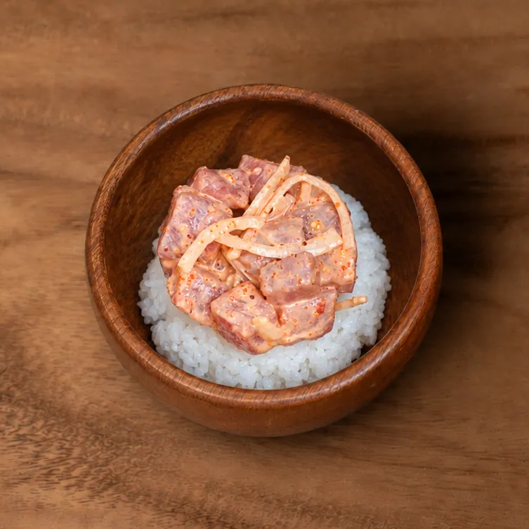 Spicy mayo tuna poke over rice in a wooden bowl
