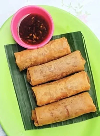 Four golden Thai crispy spring rolls with dipping sauce