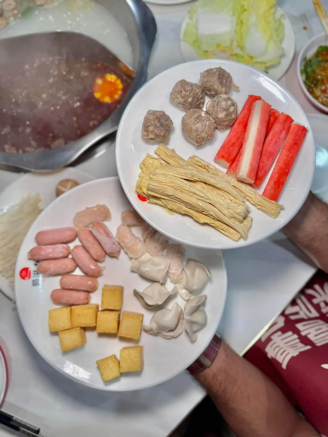 Hotpot ingredients arranged around a divided pot