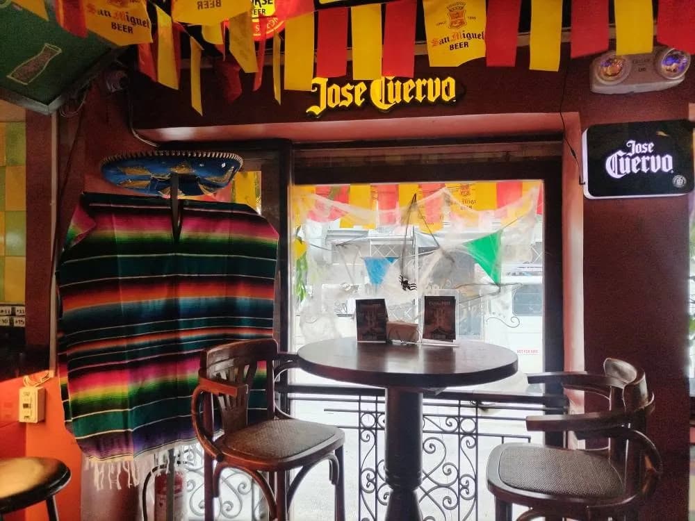 Colorful cantina table by the front window with tiled walls and framed art