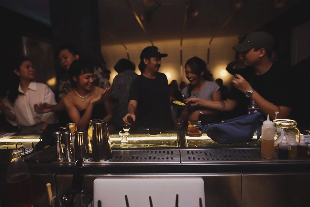 Crowd gathered around the bar counter at night