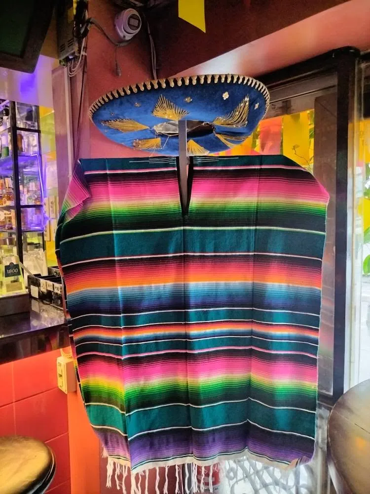 Blue sombrero and striped serape displayed beside the bar