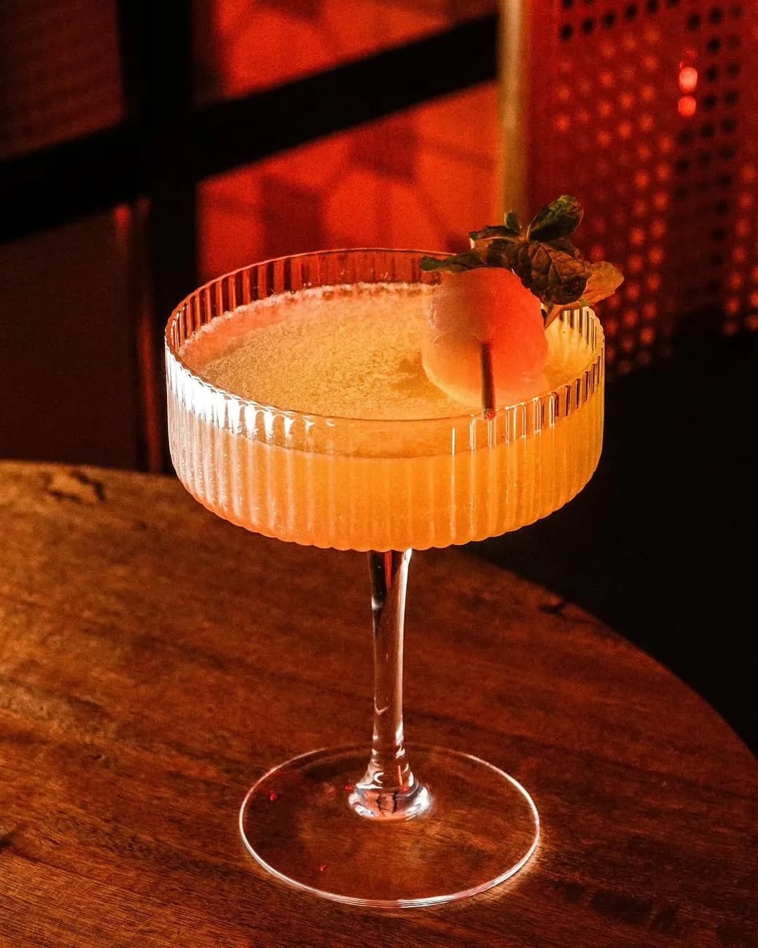 Orange gin cocktail on a dark wooden table