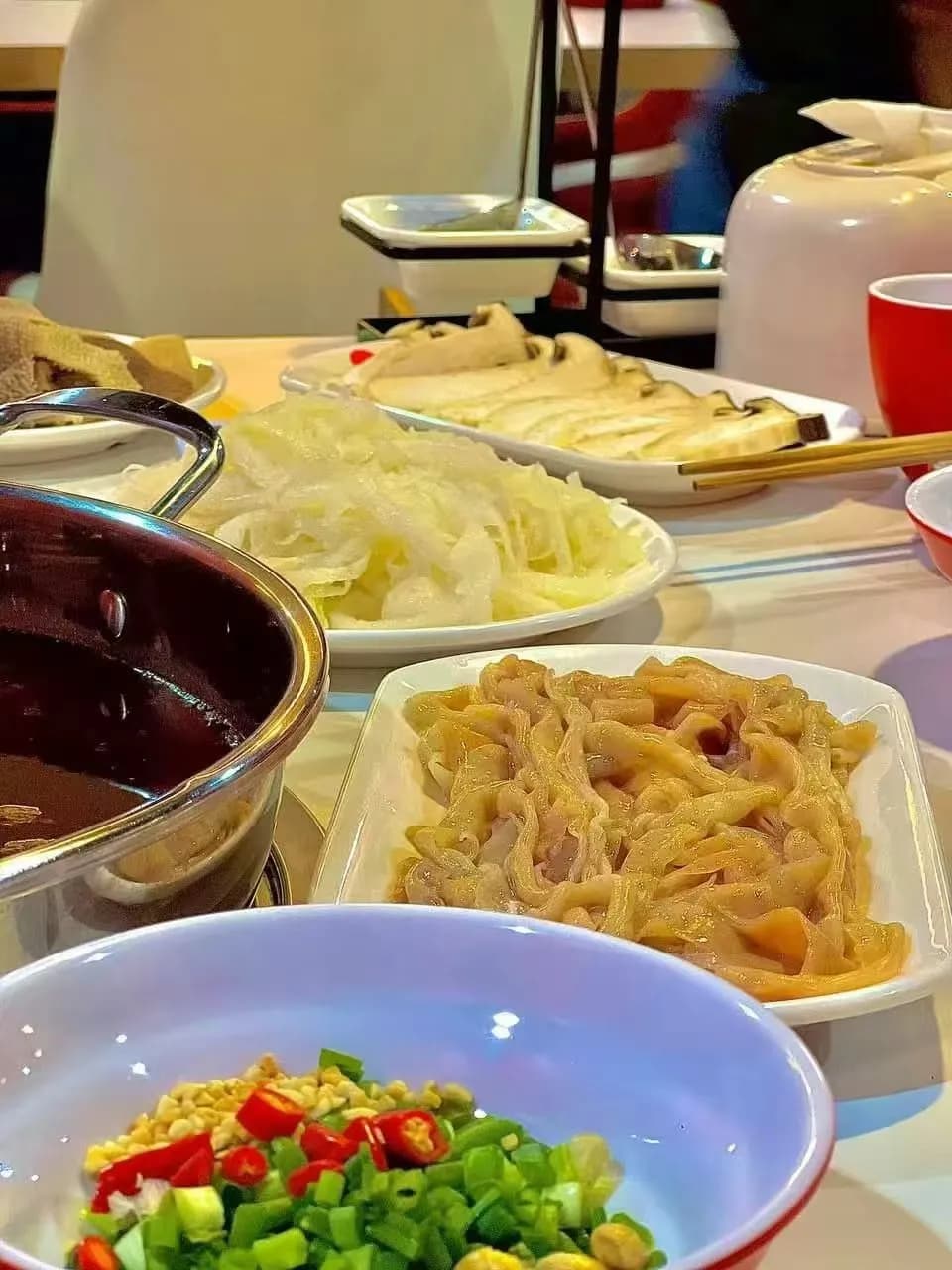 Hotpot table with noodles, vegetables and fried sides