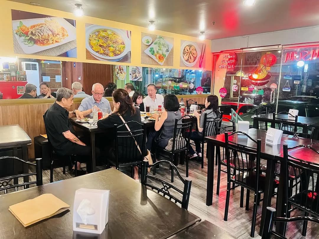 Dining room filled with guests at black tables