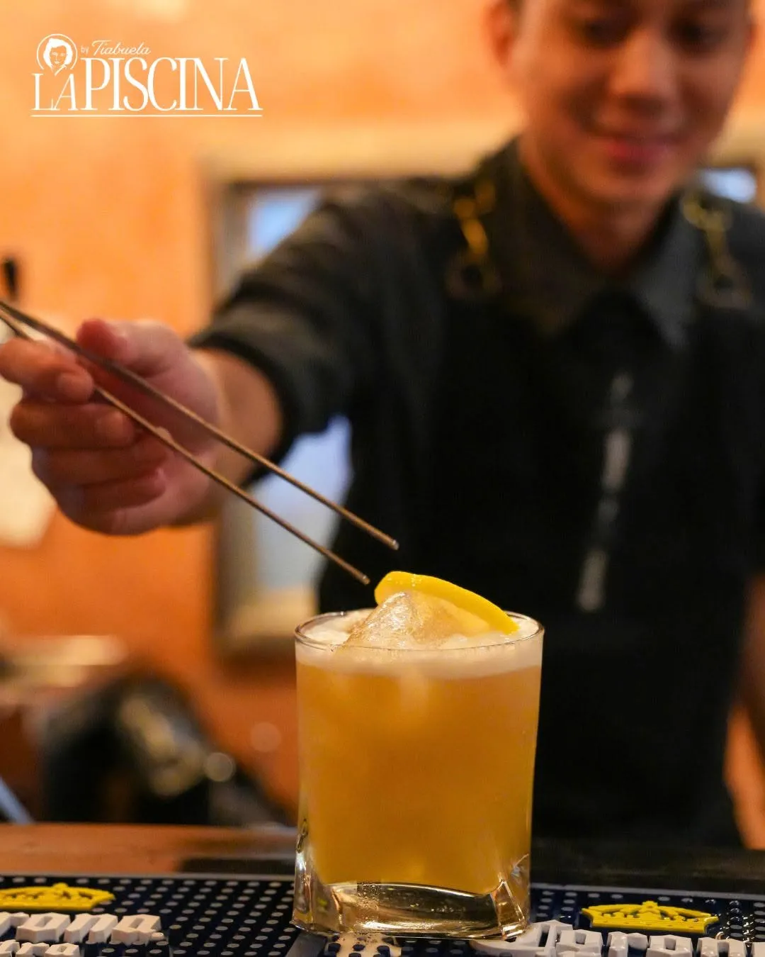 A bartender pouring a yellow poolside cocktail