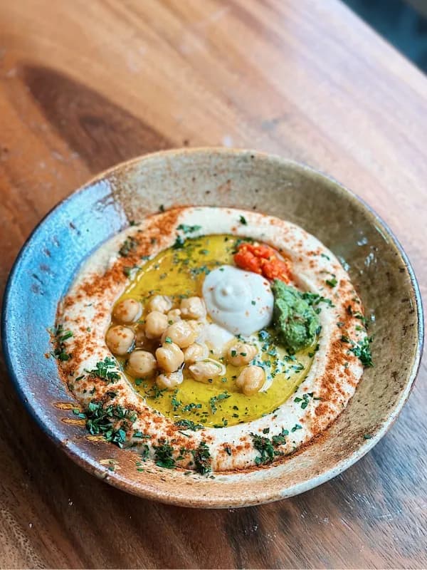 Hummus topped with chickpeas, herbs and olive oil
