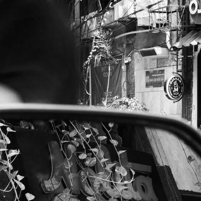 Black-and-white view of the compact Don Pedro Street entrance and outdoor seats.