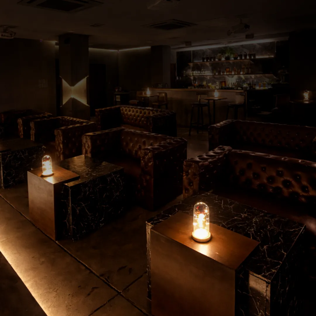 Lounge seating with marble tables and small lamps