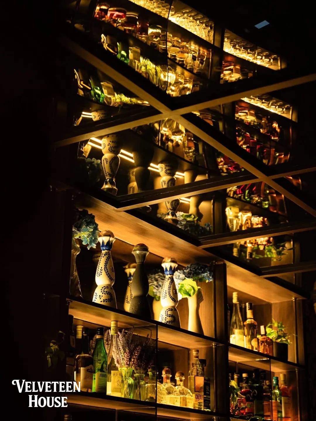 Lit back bar shelves lined with bottles