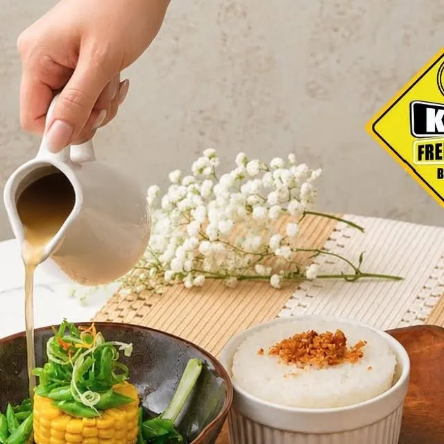 Savory breakfast plate with rice, corn and sauce being poured