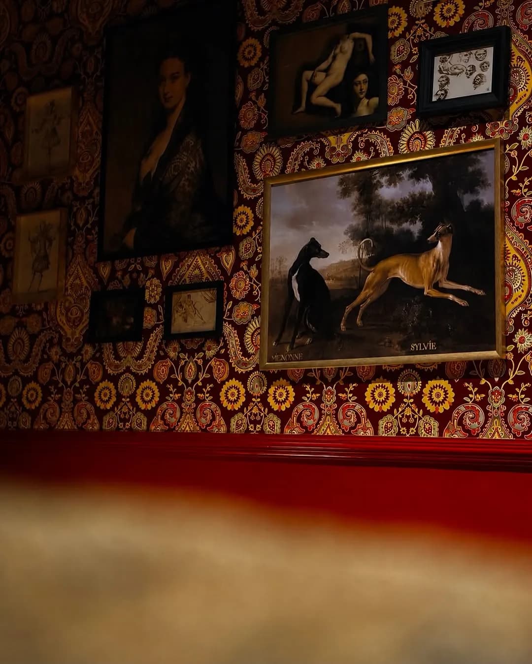 Corner of the bar with framed paintings and red lighting