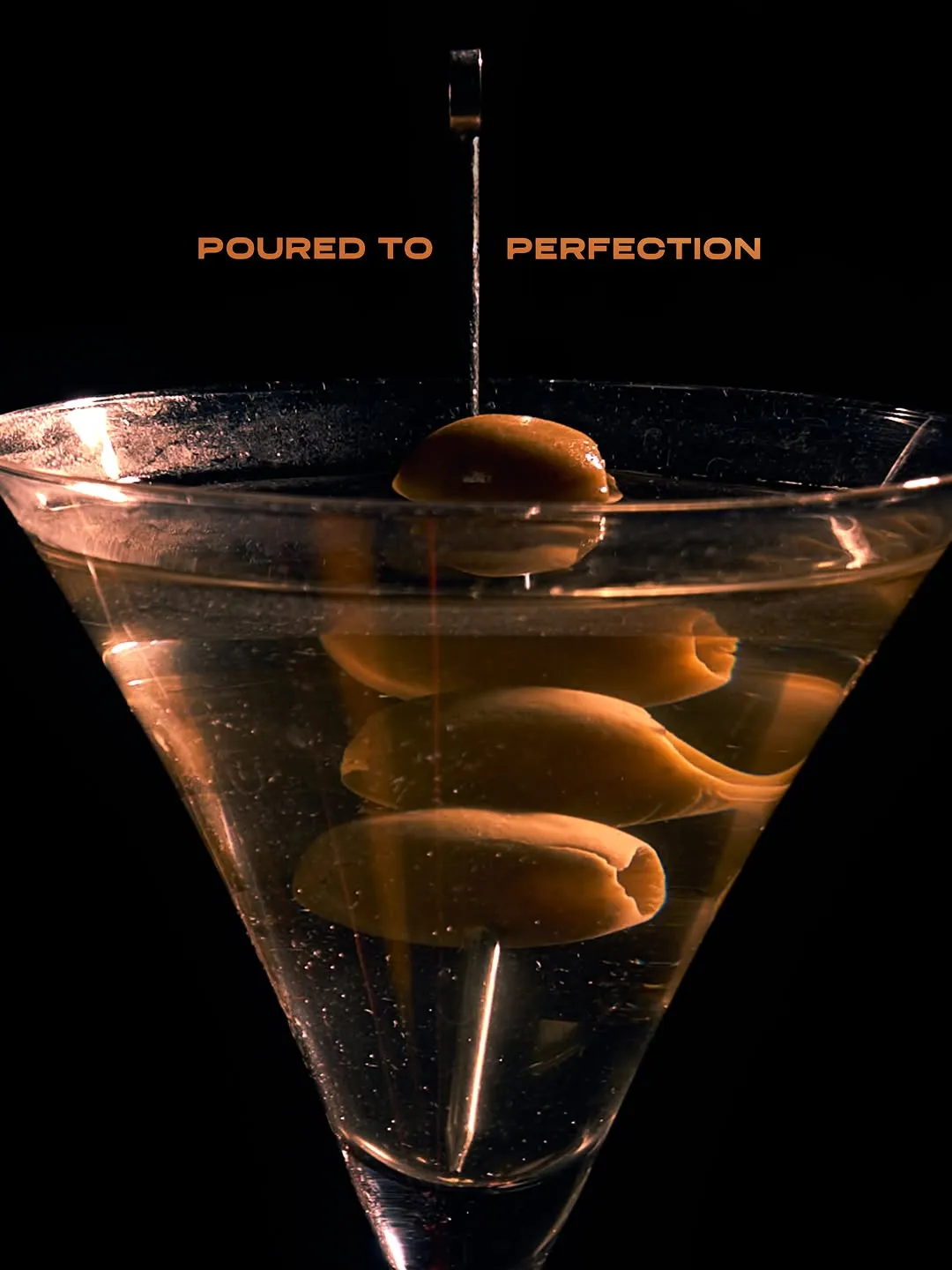 Clear martini-style cocktail with green olives