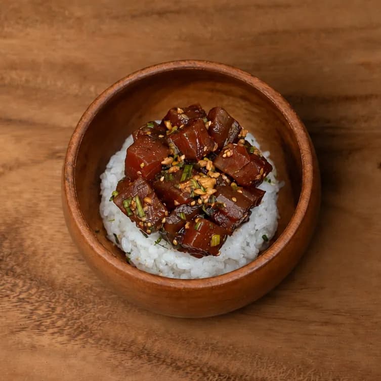 Garlic shoyu tuna poke over rice in a wooden bowl