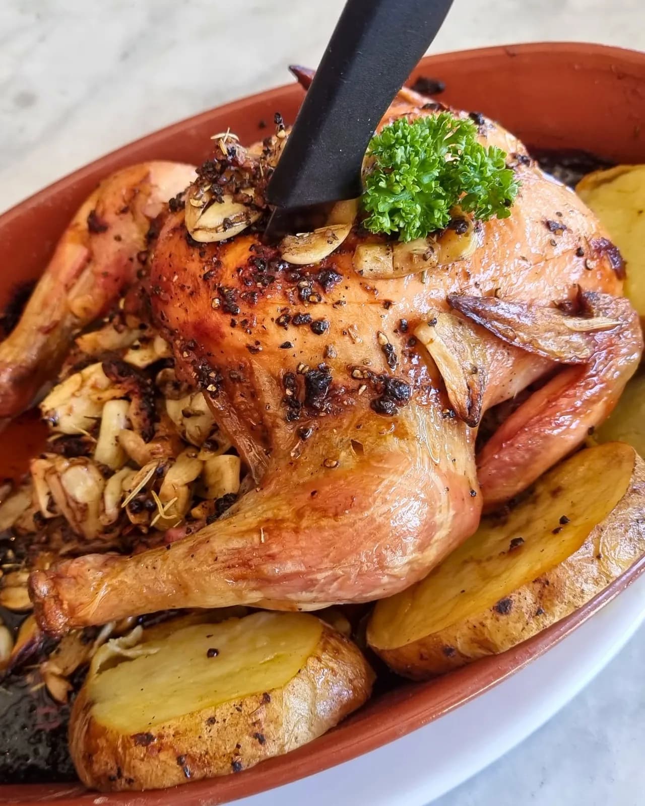 Whole roasted chicken with garlic and potatoes