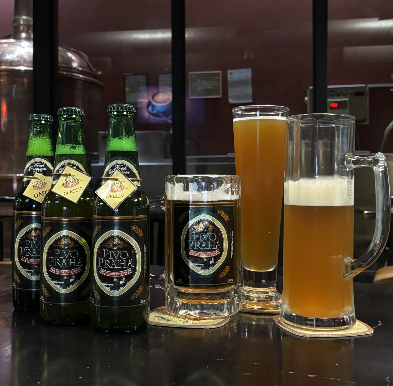 Pivo Praha Dark, Classic and Weizen bottles with three poured beers in front of copper brewing tanks.