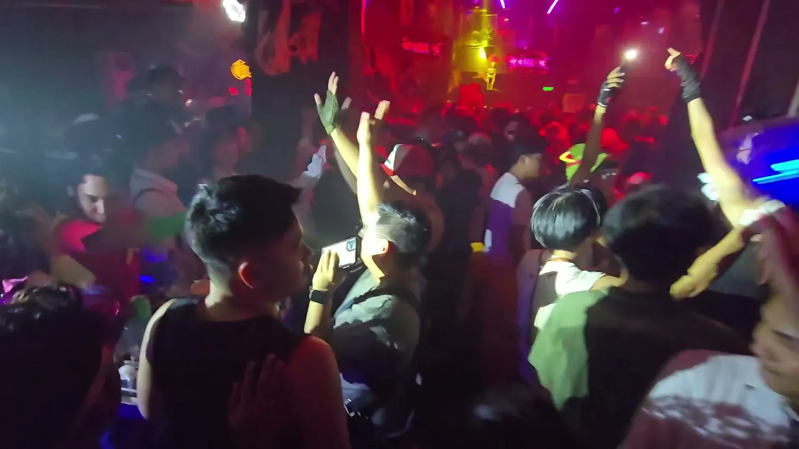 Guests dancing in a full room beneath red stage lighting