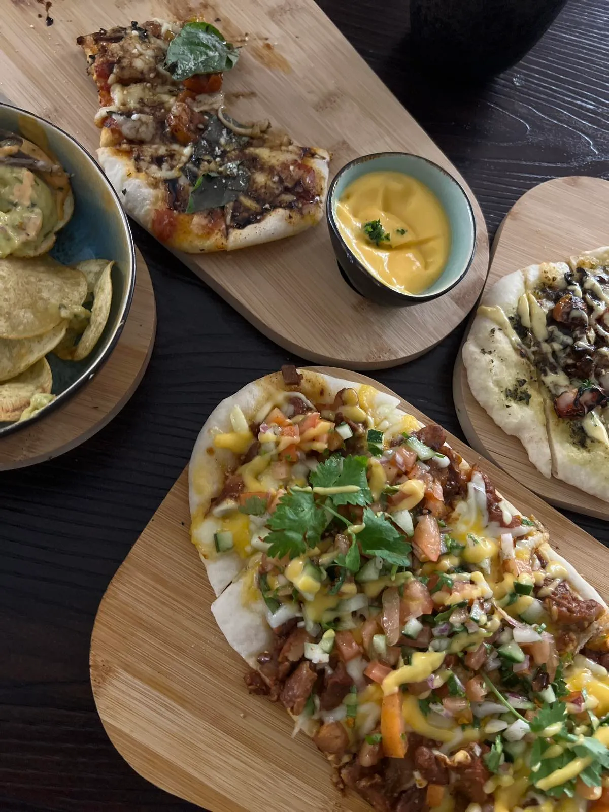 Flatbread pizzas and chips served on wooden boards
