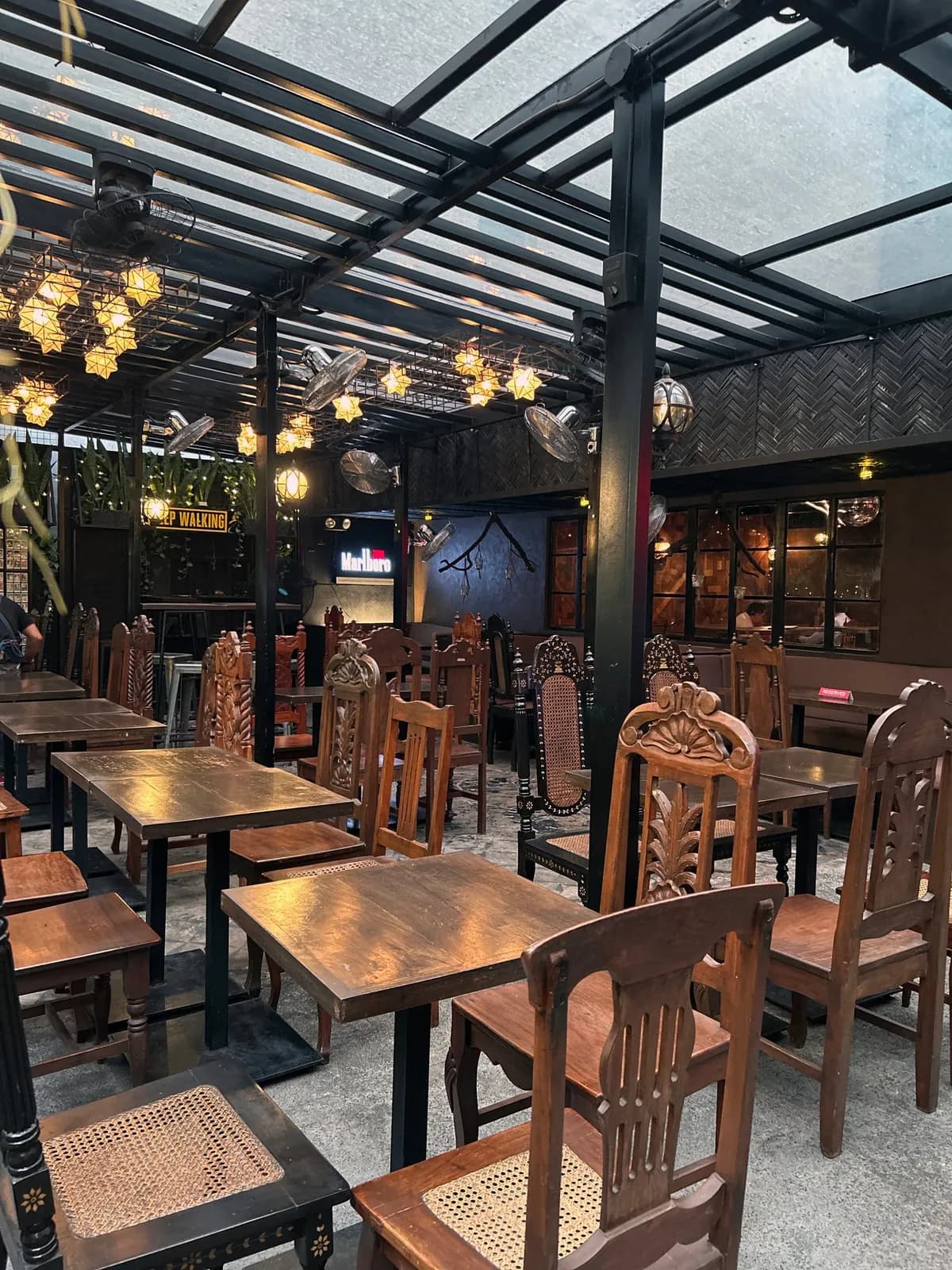 Wooden patio seating under Capiz star lights at Alamat