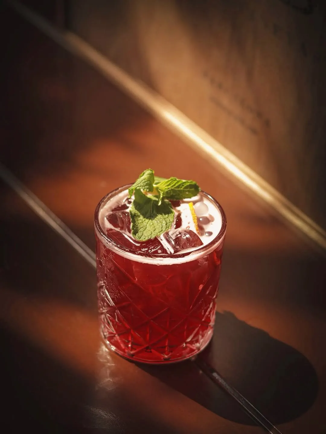 Red cocktail in a stemmed glass on the bar