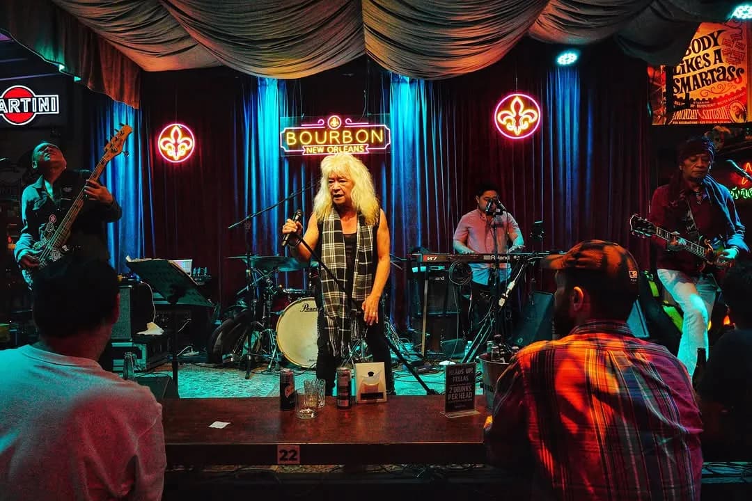 Live band performing on Bourbon's red-curtained stage