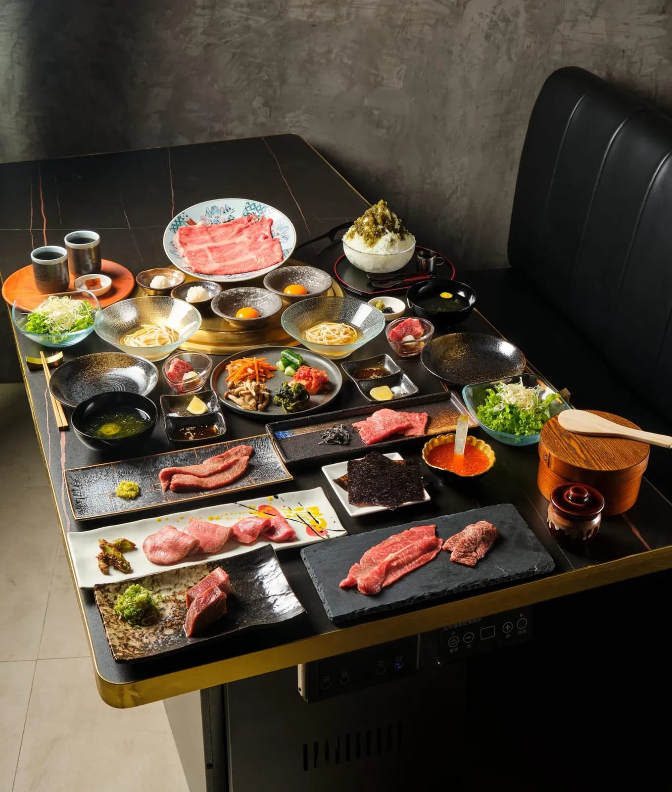 Full yakiniku course spread with raw Wagyu cuts, salads, noodles and shaved ice