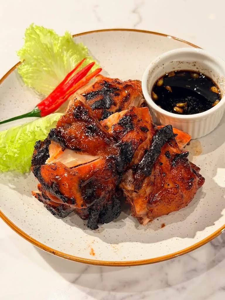 Charred grilled chicken served with lettuce, chillies and dipping sauce