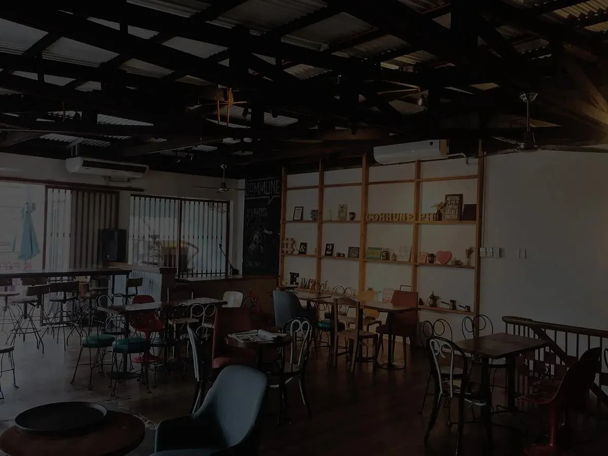 Commune's upstairs event space with mixed chairs, tables and open shelves.