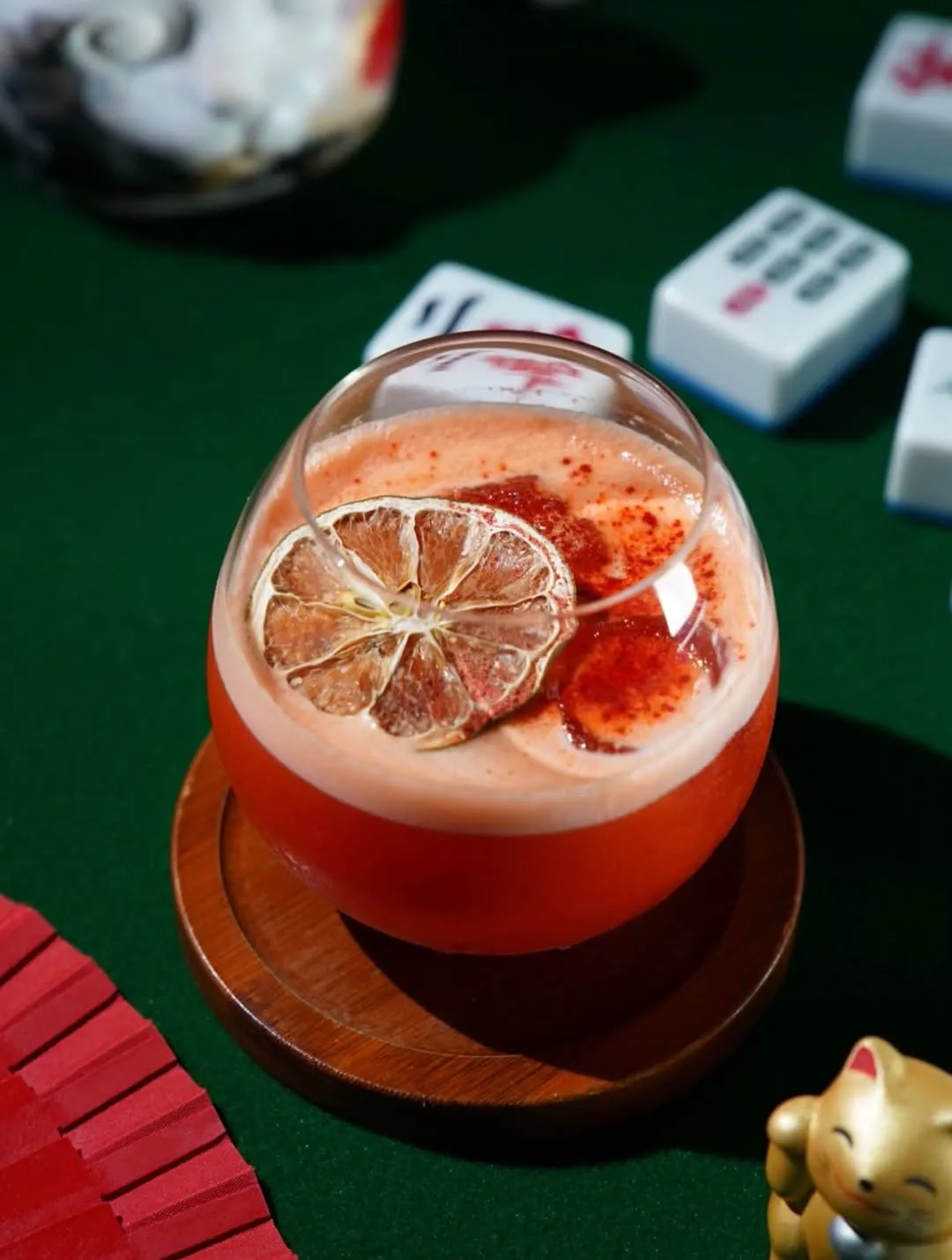 Red citrus cocktail on a green table