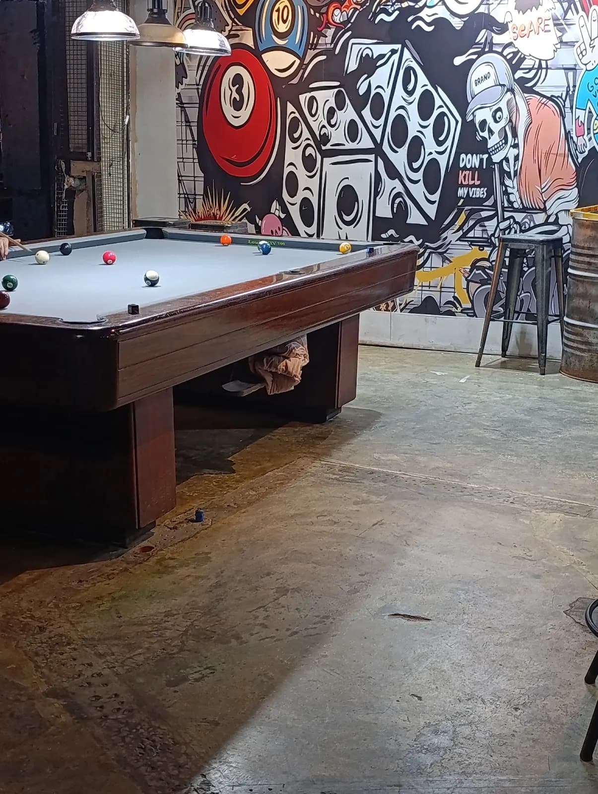 Pool table beside a black-and-white games mural inside Evolution