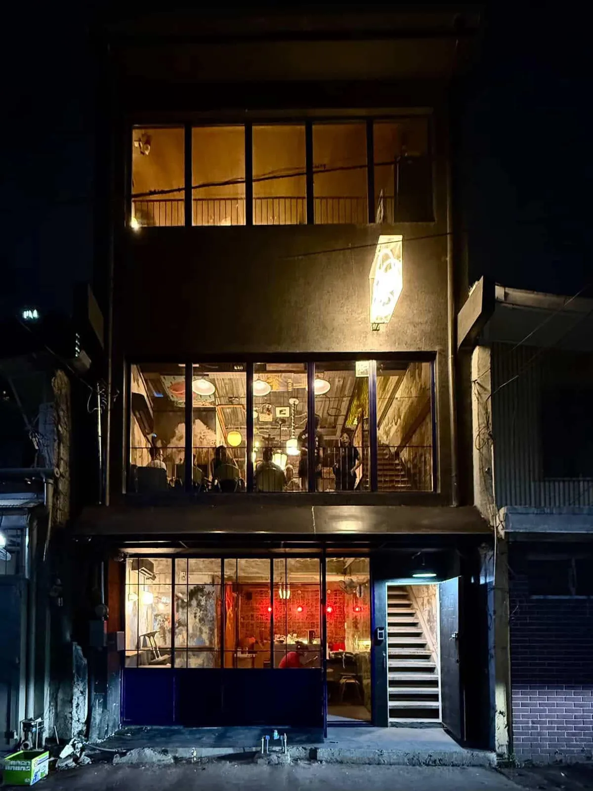 Three-story Rekdi facade glowing at night on Pagulayan Street
